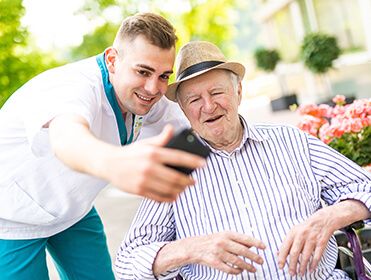 Pfleger macht Handyfoto mit Bewohner