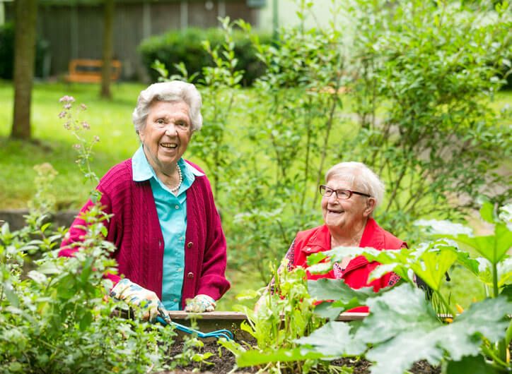 Zwei Bewohnerinnen arbeiten gemeinsam im Garten