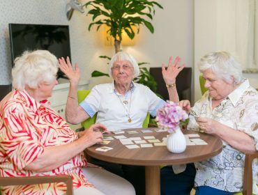Drei Bewohnerinnen sitzen am Tisch und spielen Memory